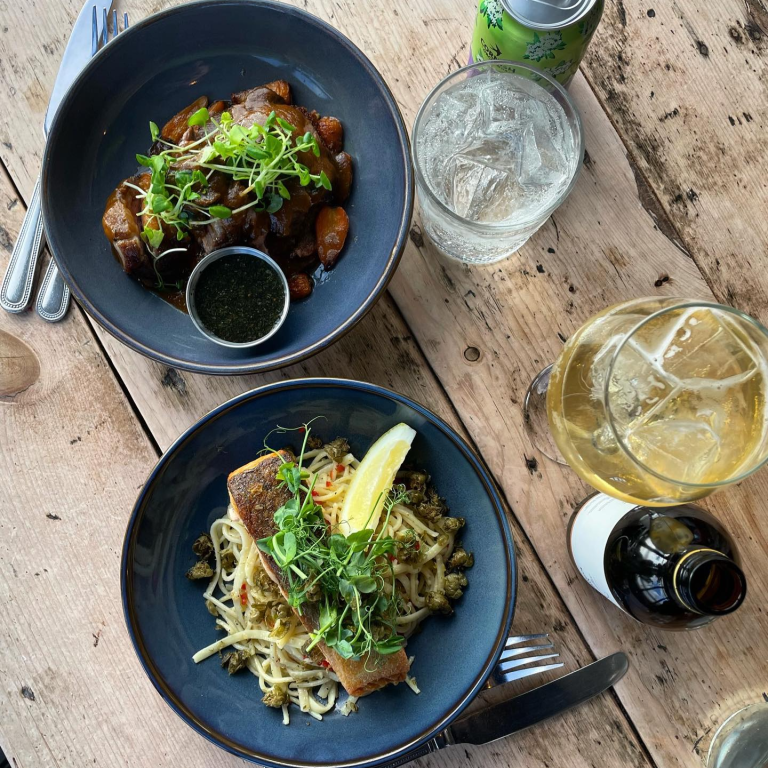 Two bowls of food on a rustic wooden table.