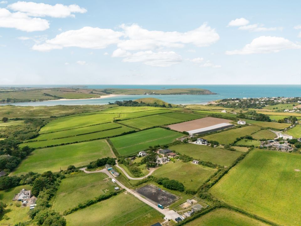 Aerial view of a coastal landscape featuring fields and scattered houses.