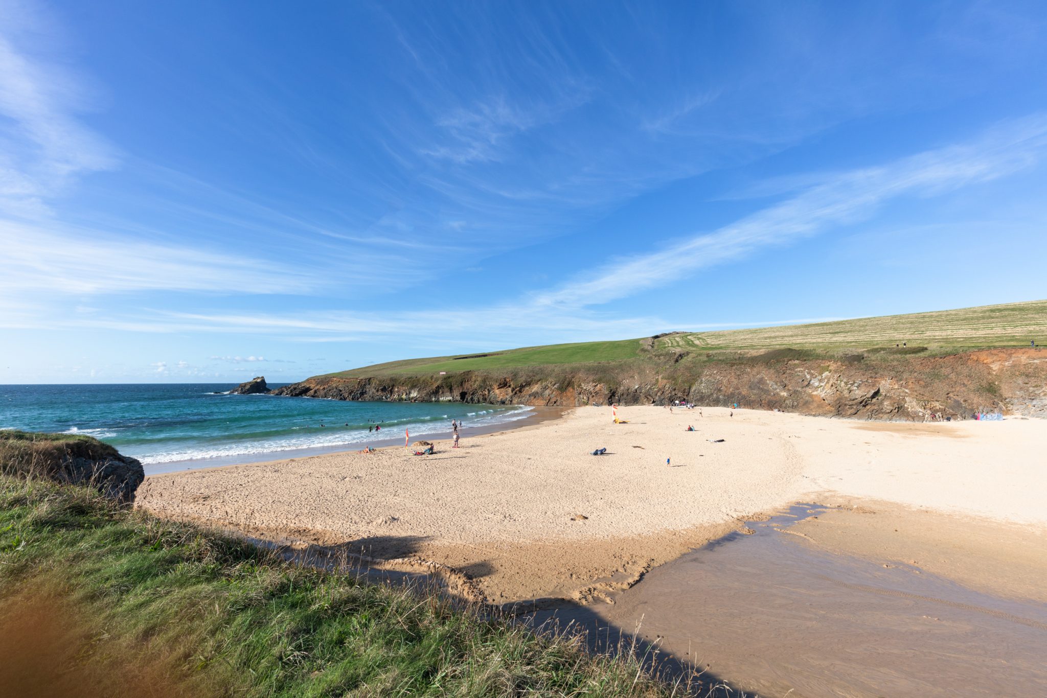 A sandy beach with people enjoying the shore.