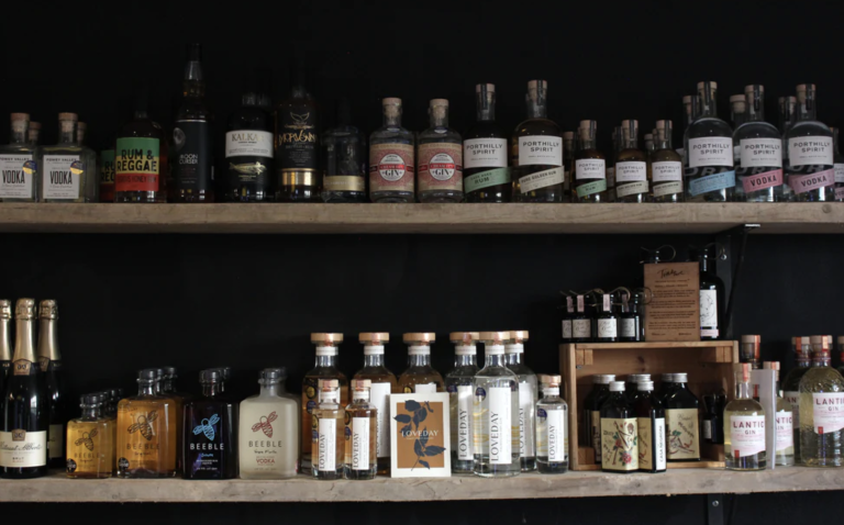 Bottles of assorted alcohol line two wooden shelves