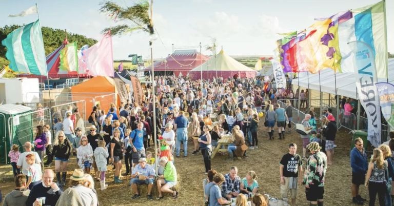 An outdoor festival with colourful tents and flags