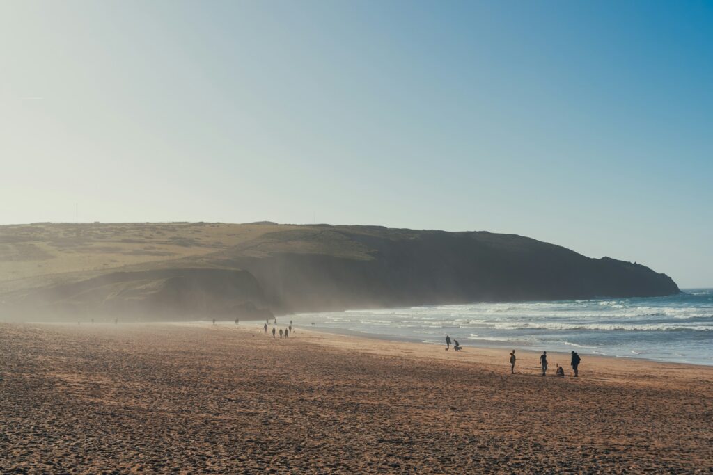 Wide sandy beach with scattered people walking